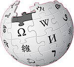 Ein fast fertig gepuzzelter Ball mit Zeichen auf den einzelnen Steinen: das Wikipedia-Logo.