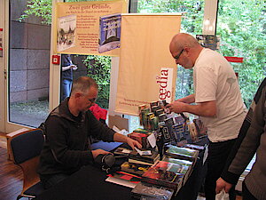 Michael Schmidt vom Zwielicht-Magazin und Michael Haitel von p.machinery belagern den Begedia-Stand auf dem BuCon 2013